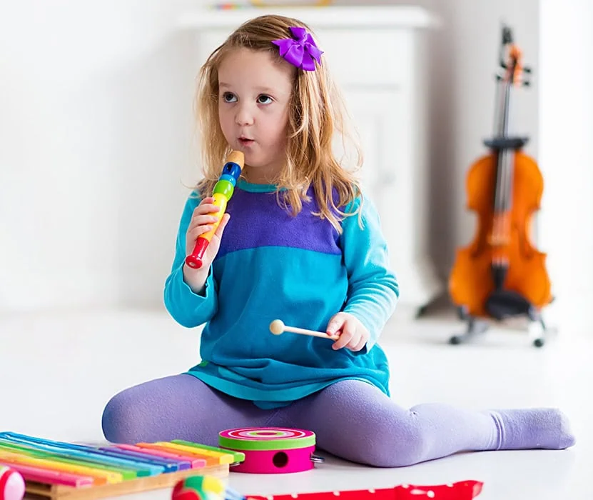 child playing with a toy recorder