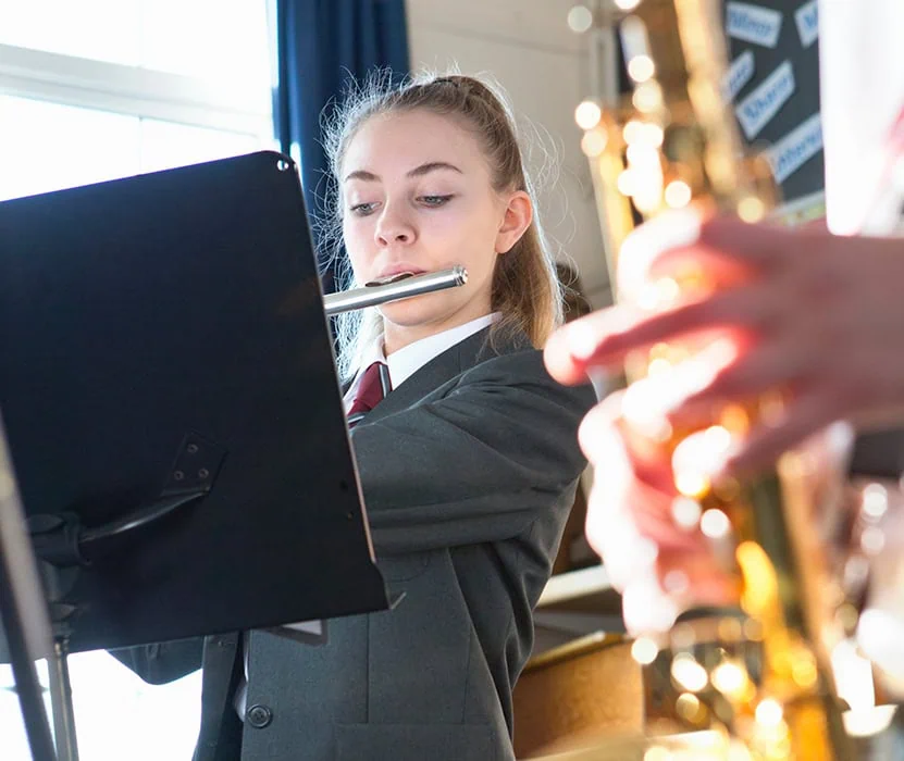 student playing the flute at school