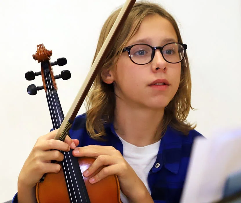 girl with a violin reading a music sheet